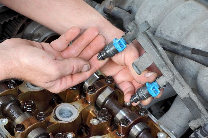 Mecânico manuseando bicos injetores do motor